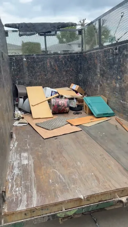 Inside the dump trailer, loaded with boards, boxes and household junk